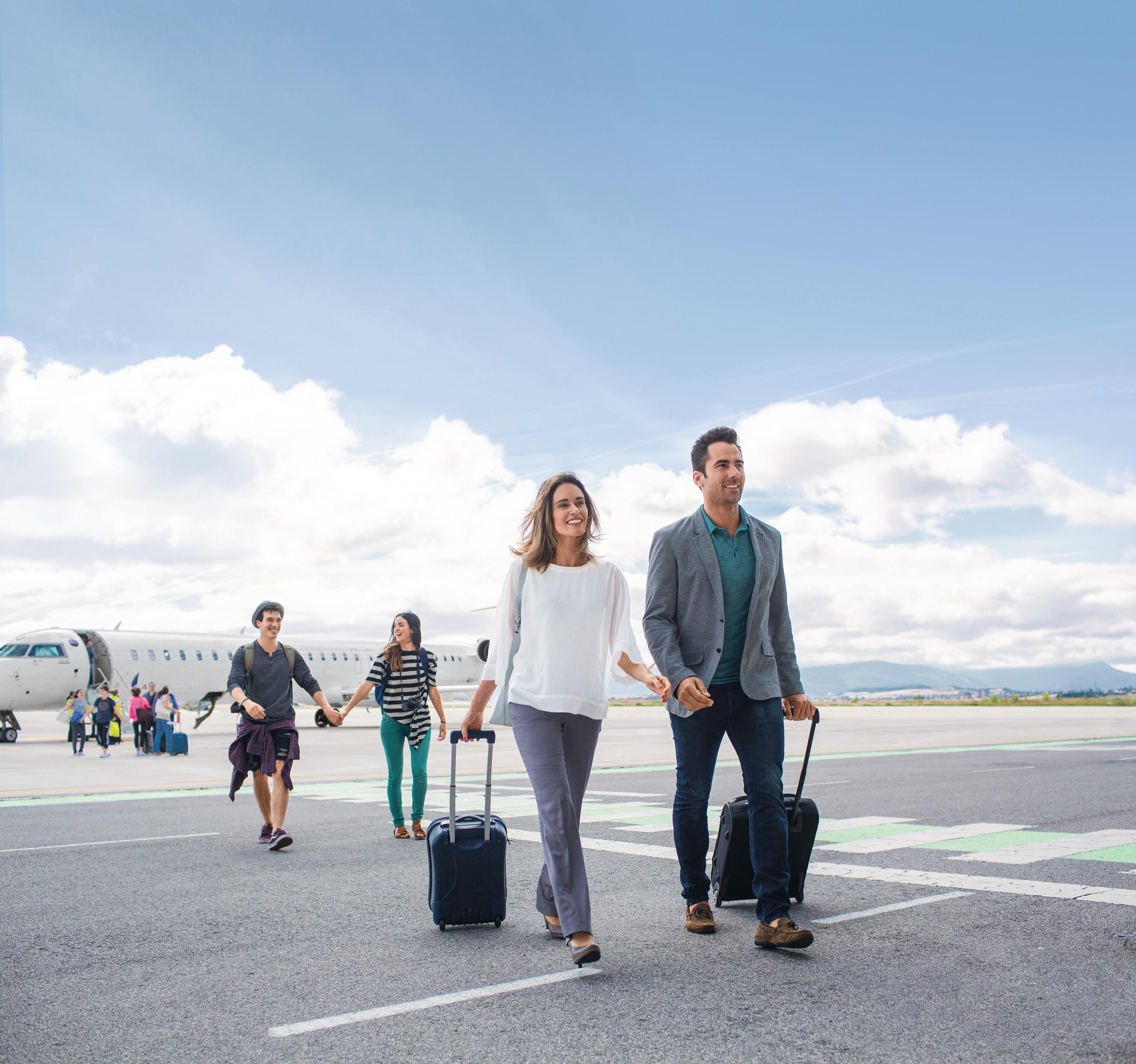 Familie auf dem Rollfeld - Kreuzfahrtversicherung Reiserücktritt Eine Familie geht auf dem Rollfeld eines Flughafens. Im Hintergrund kann ein Flugzeug sehen.